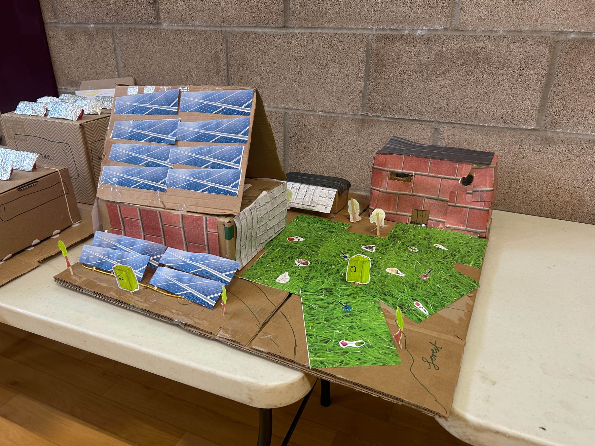 Cardboard model with a pointed roof and paper solar panels