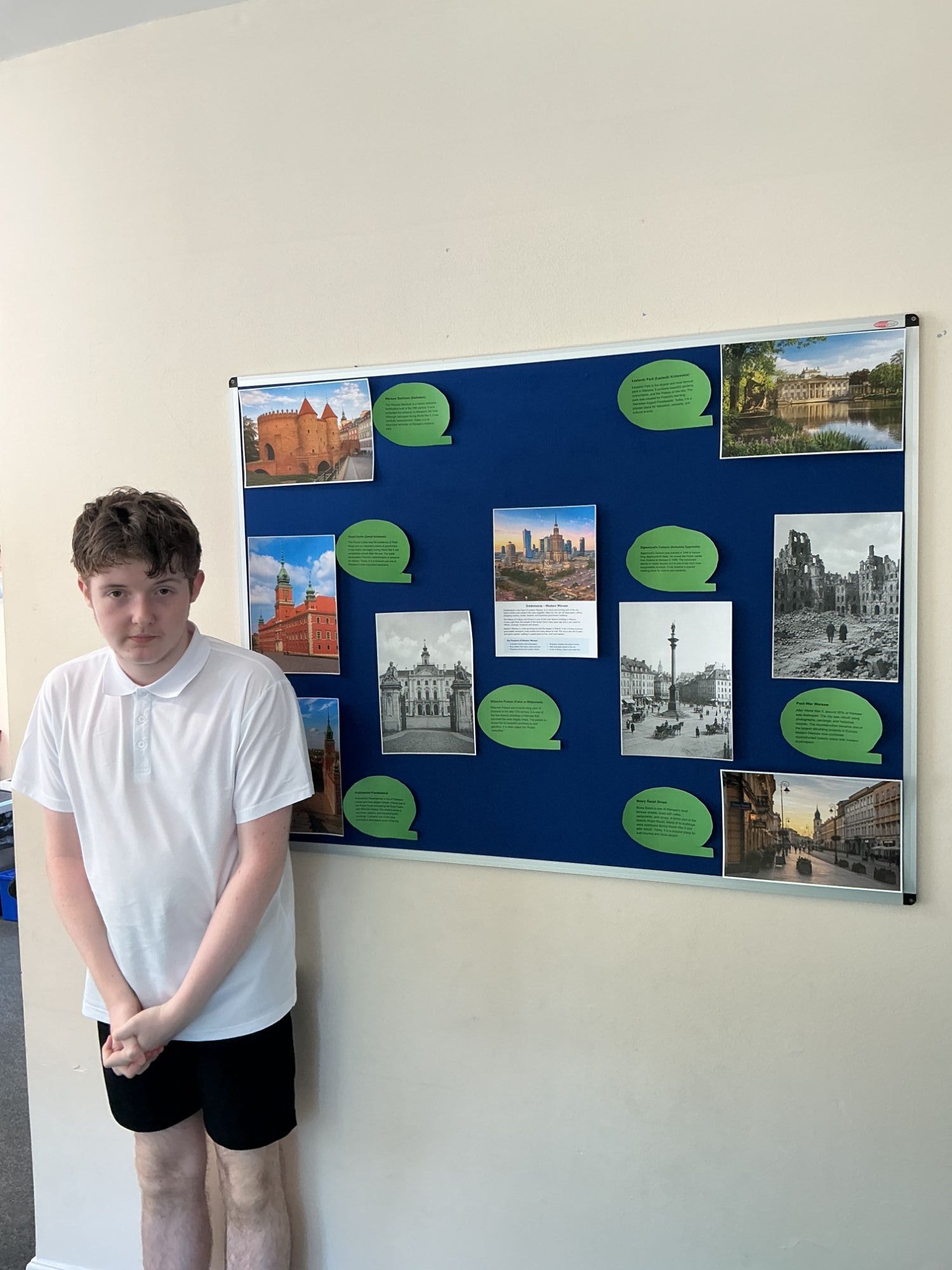Boy 3 standing by the Warsaw display board