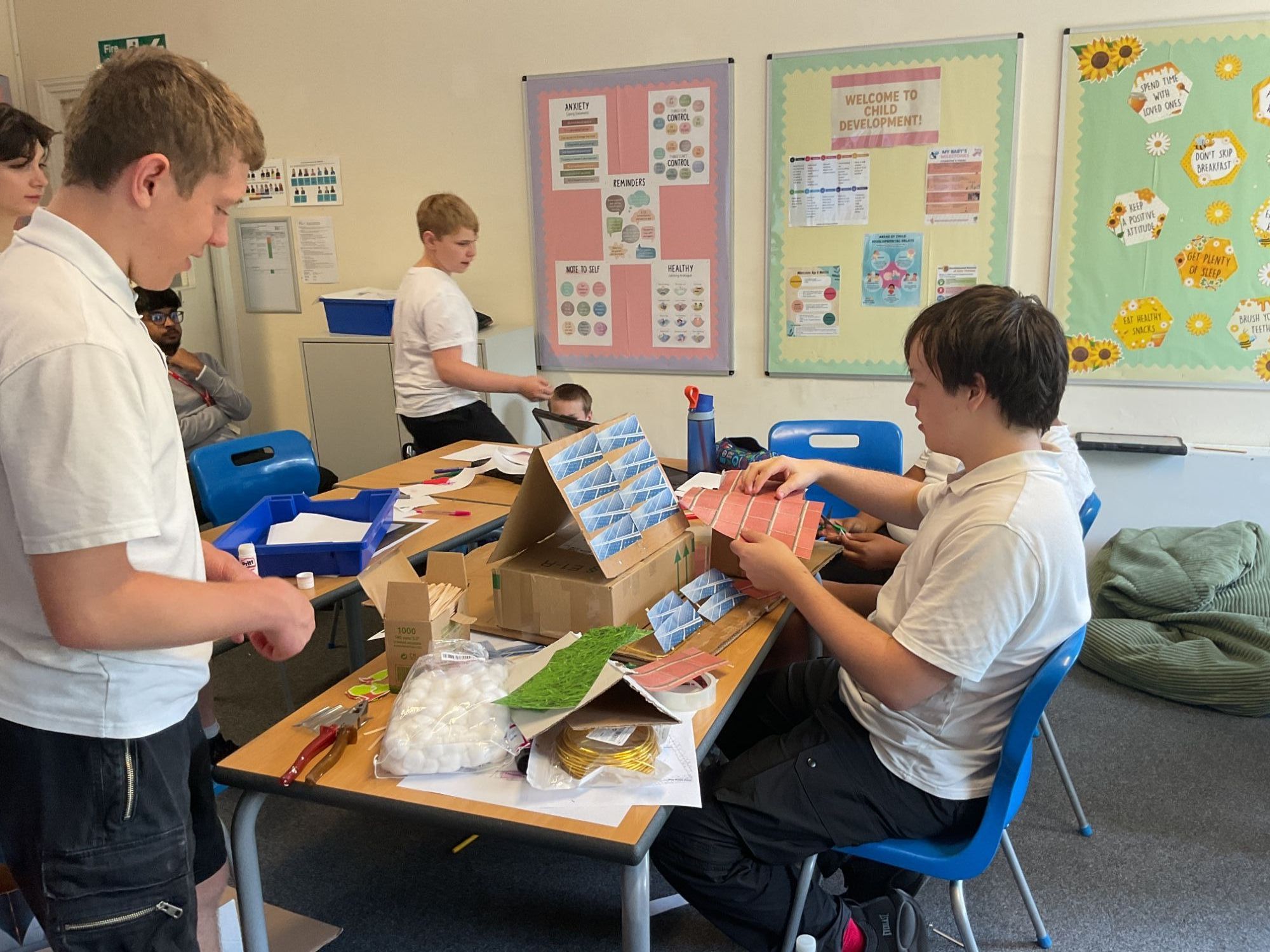 Students building their model school out of cardboard