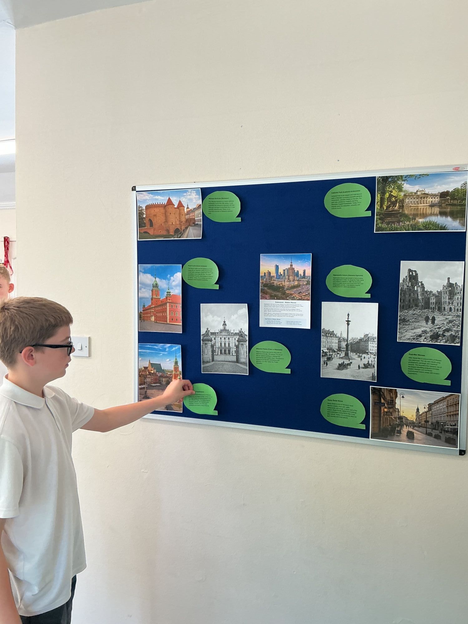 Boy 2 pointing at Warsaw display board 