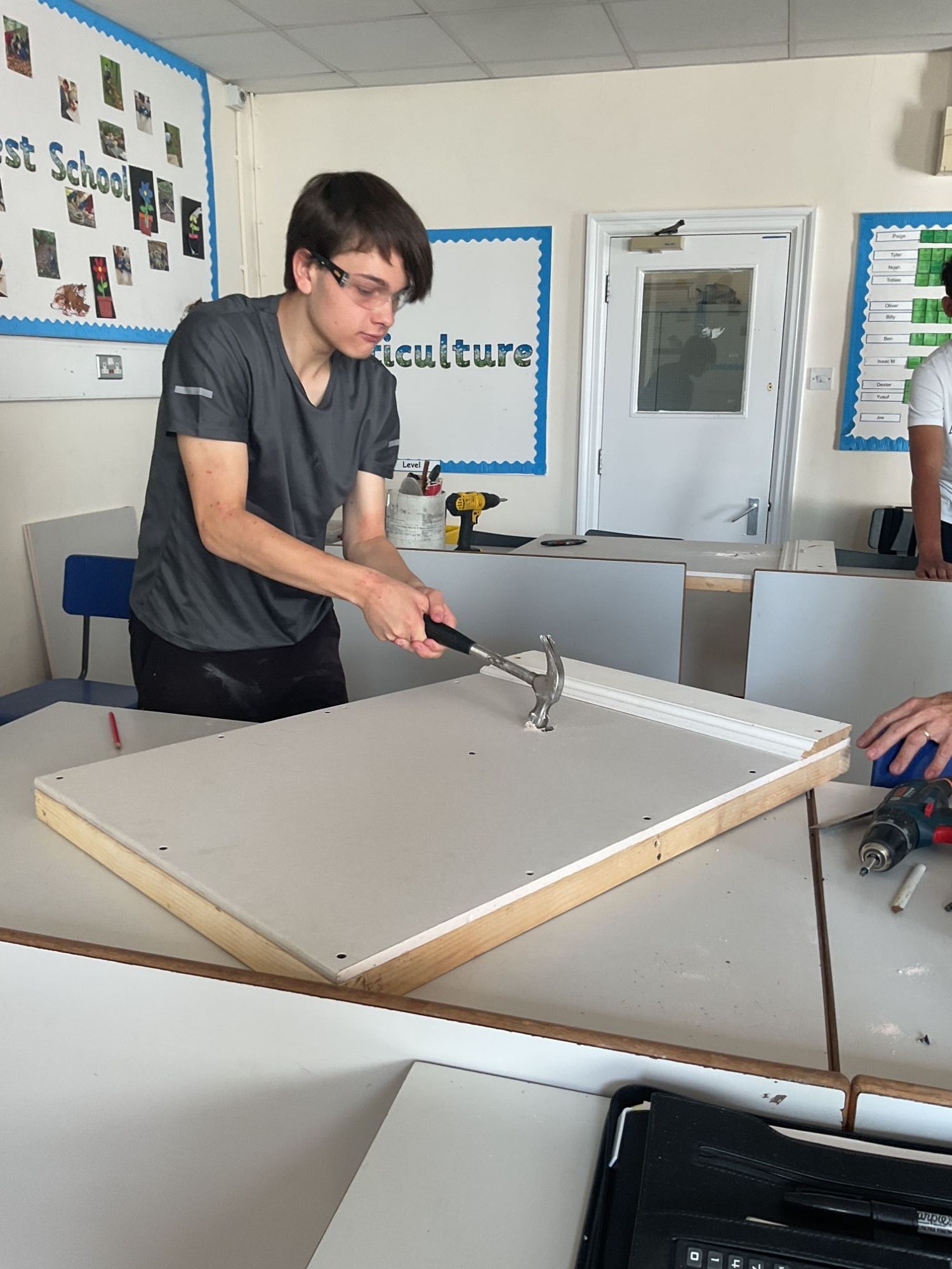 Boy hitting plasterboard with a hammer ready to repair