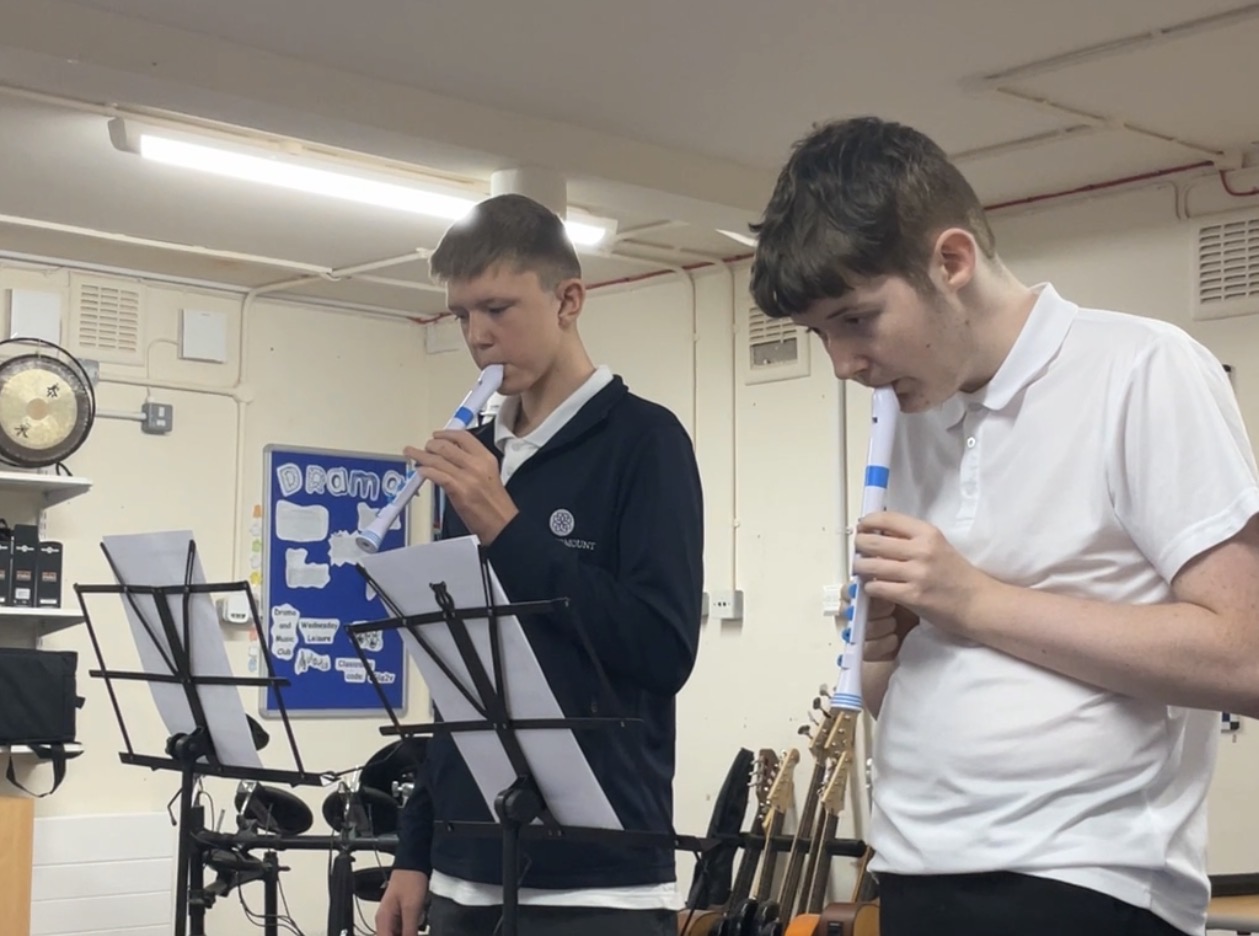 Recorder Two students stood up playing the recorder