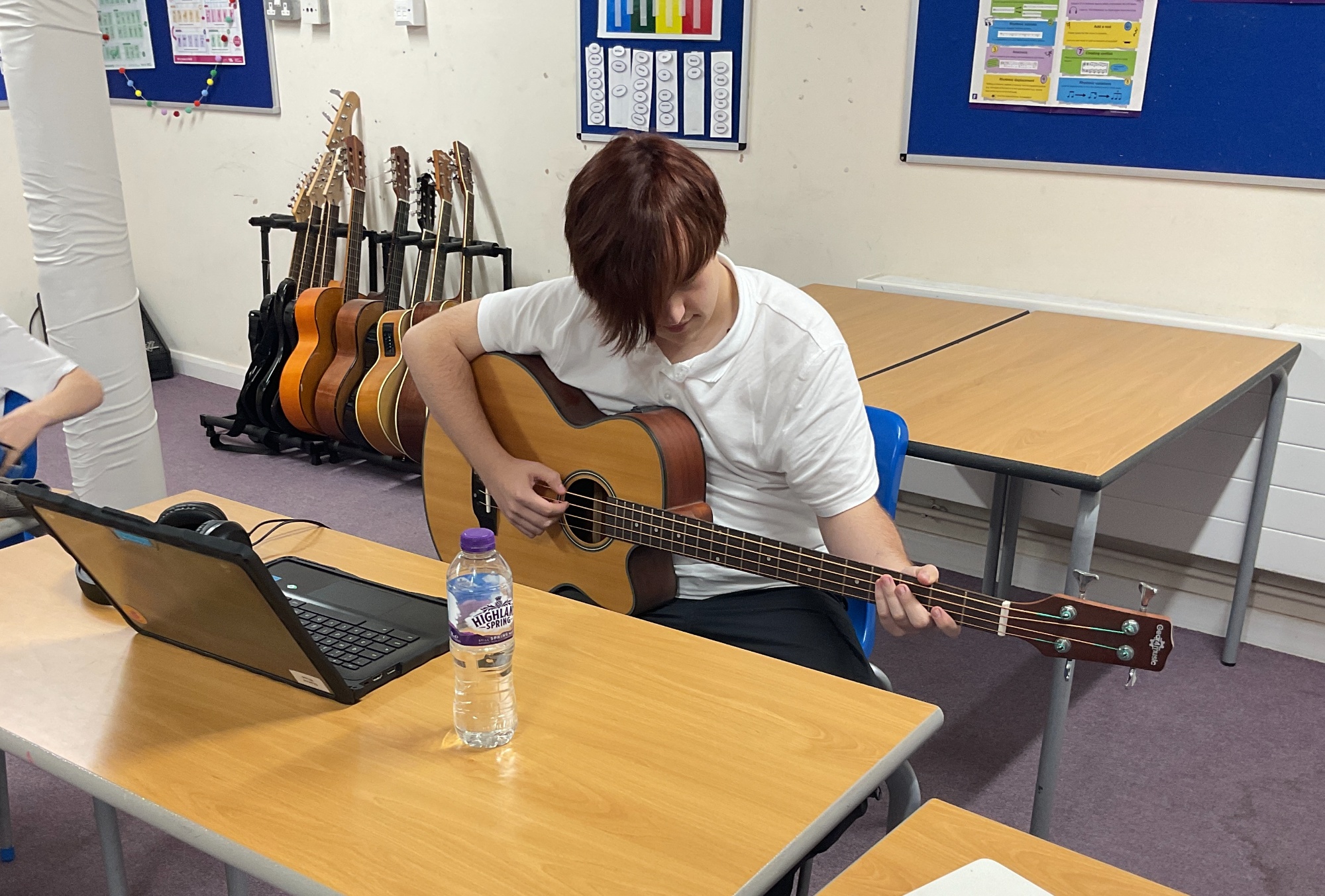 Student playing an acoustic guitar