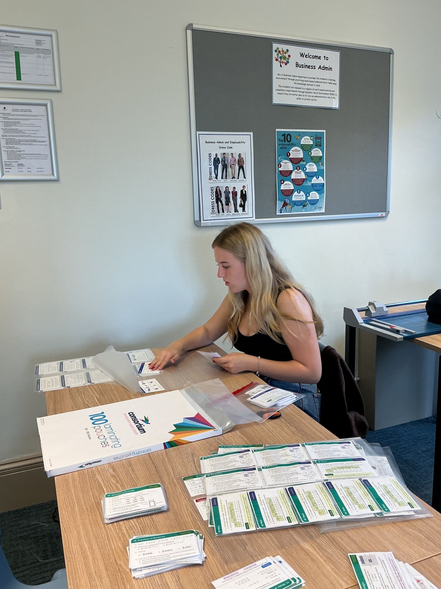 Girl sat at a desk carefully arranging paper