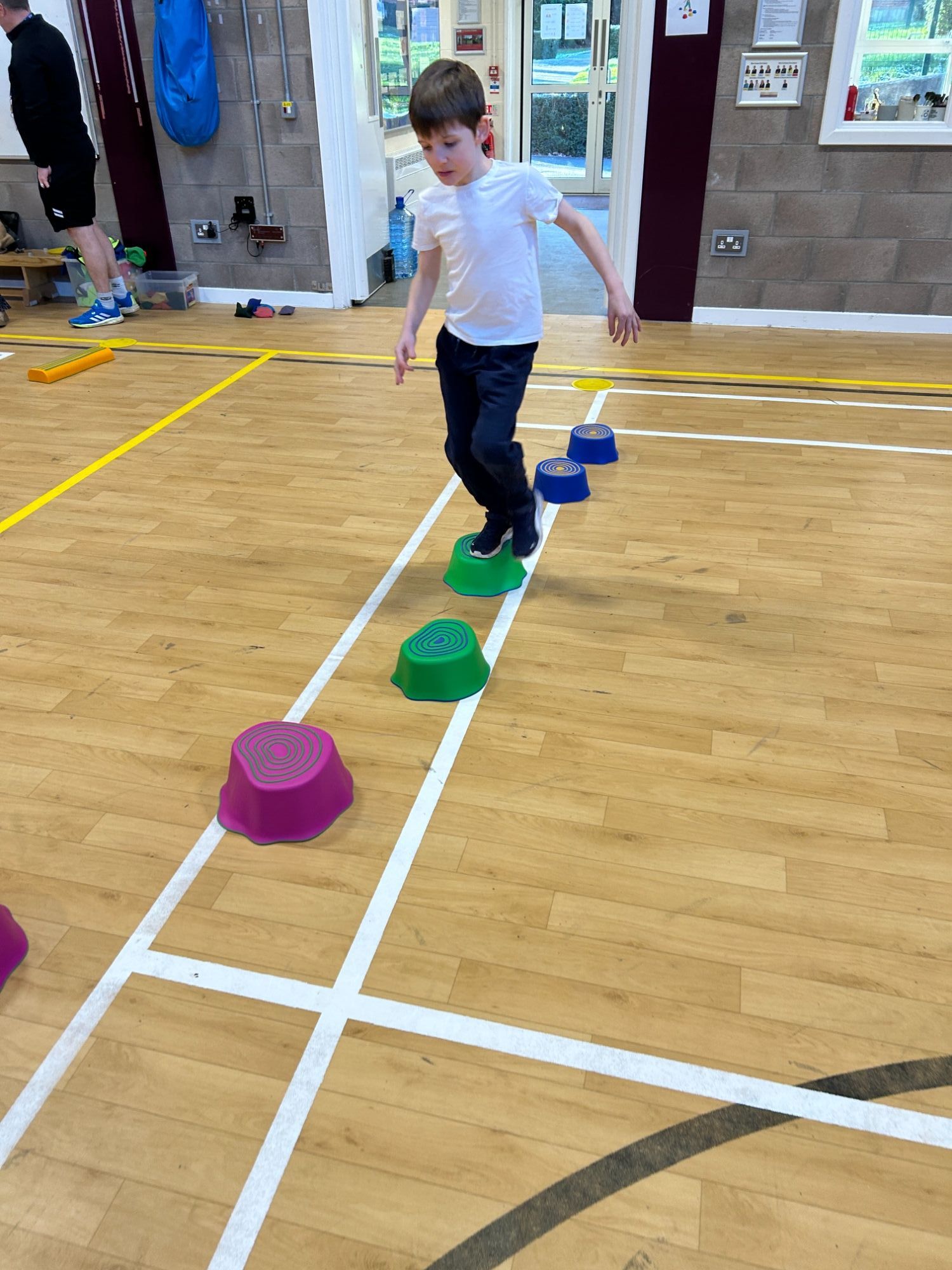 Boy practicing his balance walking on stepping stones