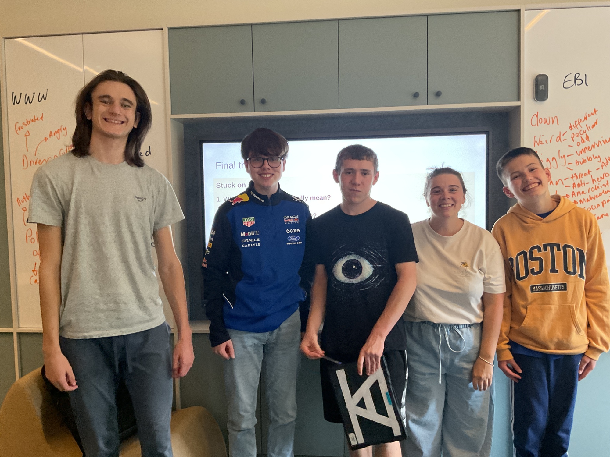 A group of students and a teacher in jeans in the English room