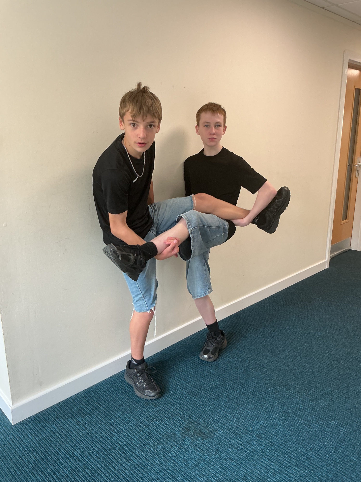 Two boys in Jorts both tanding on one leg!
