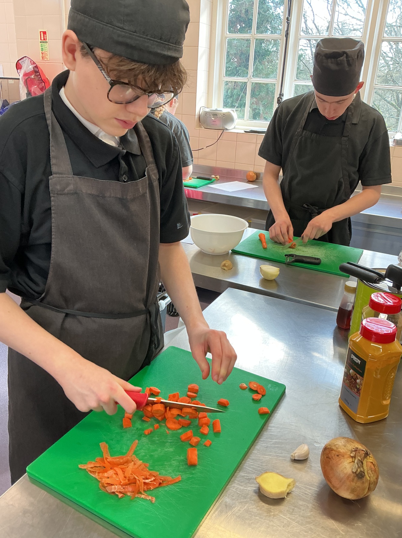 Two students chopping vegetables