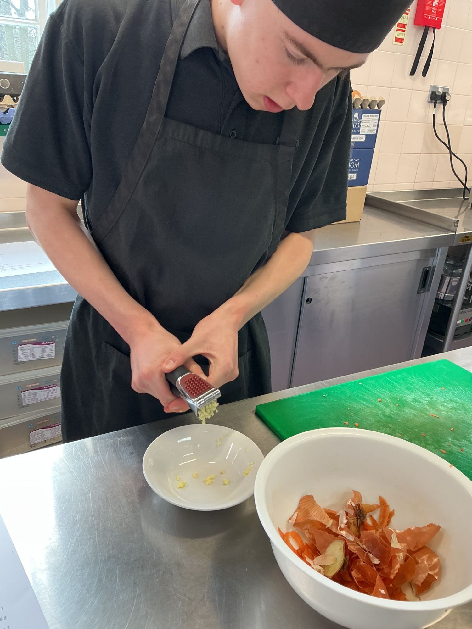 Student using a garlic crusher