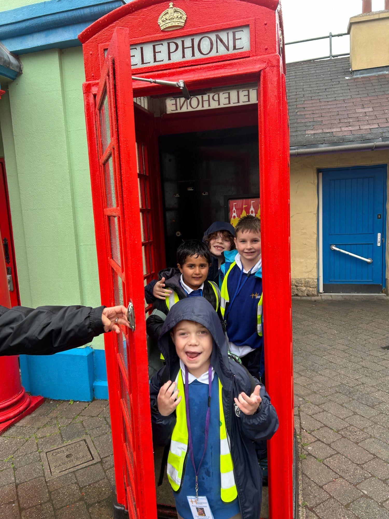 Students smiling squeezed into a phone box
