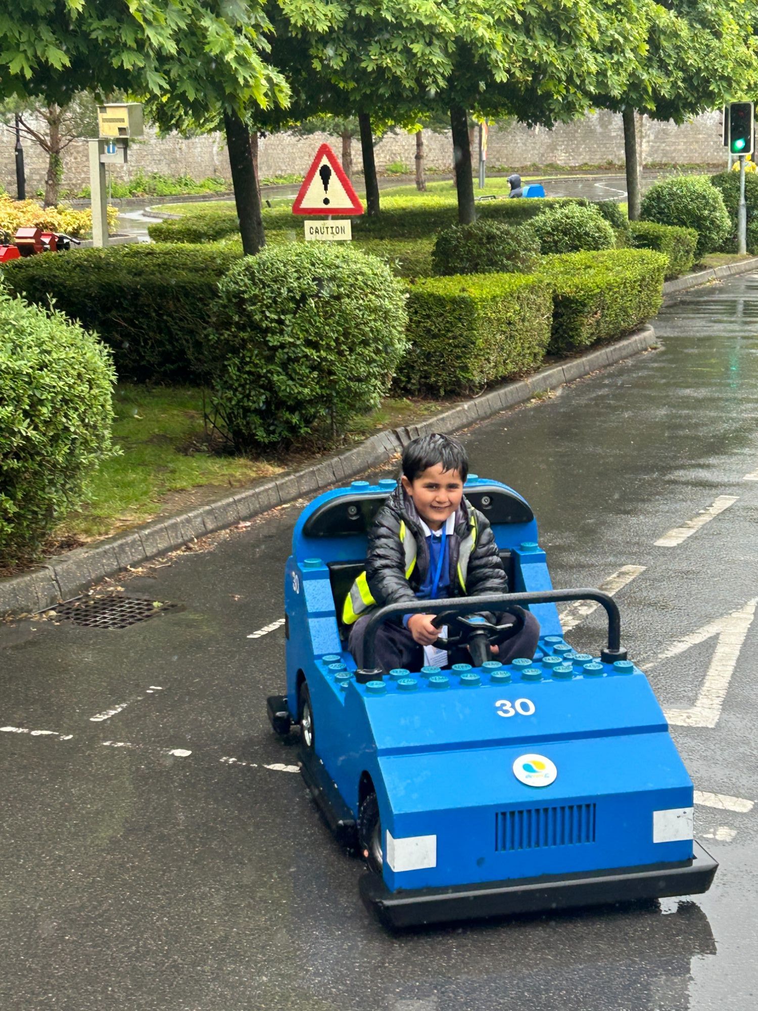 Close up of a student driving a blue lego car