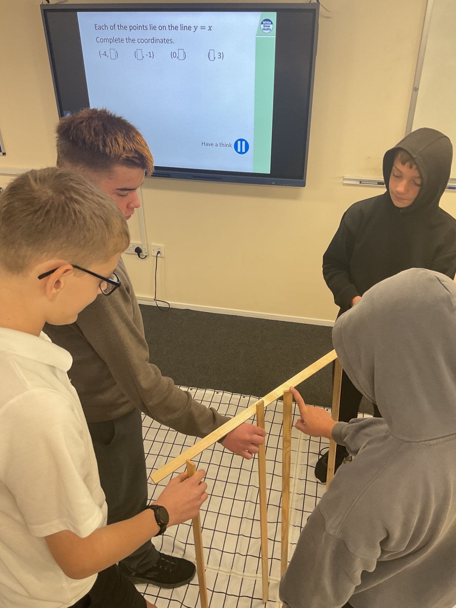 Four students physically plotting a graph