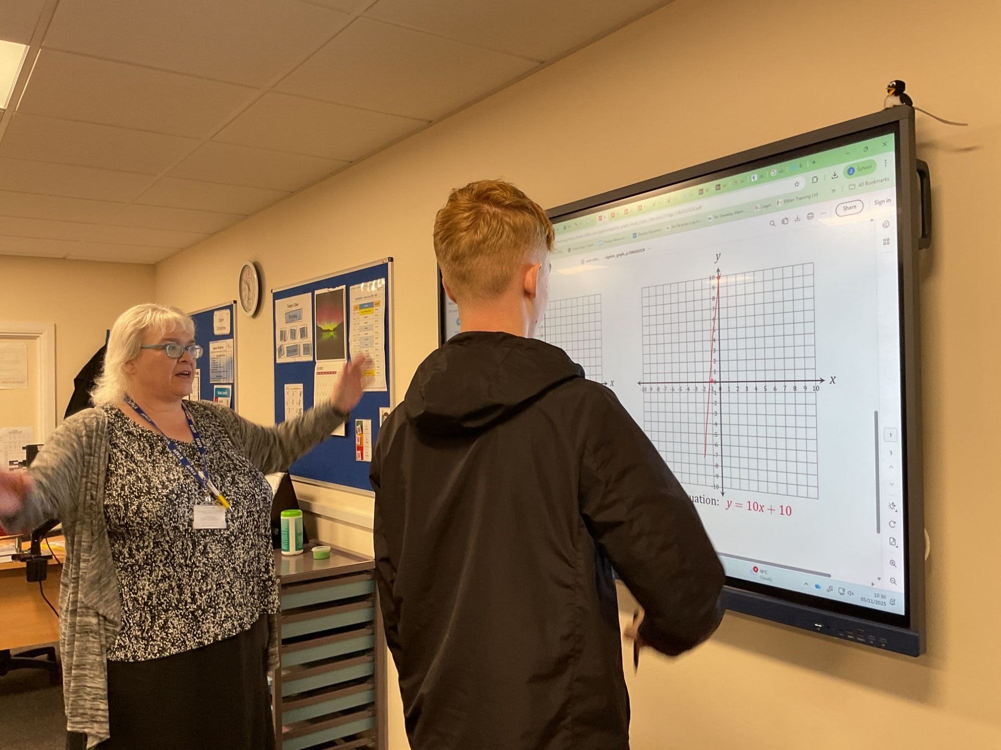 Anbother students looking at graphs on the whiteboard with the teacher