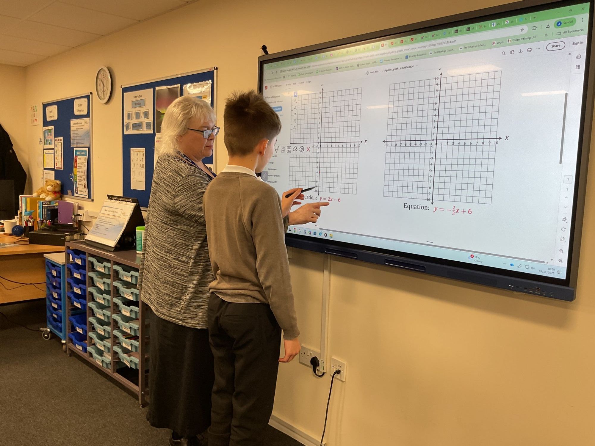 Teacher and student looking at graph on the whiteboard