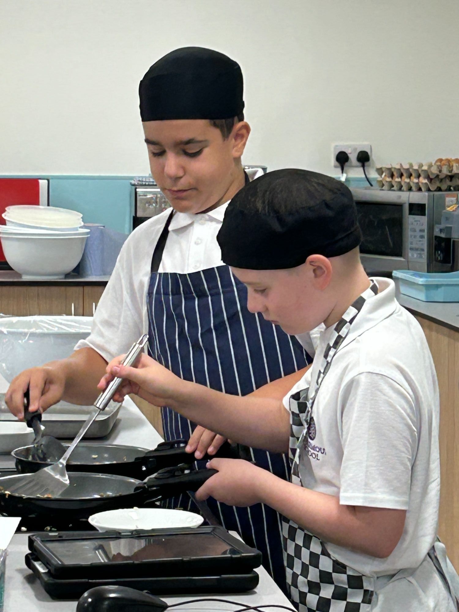 Close-up of students frying in the new catering classroom