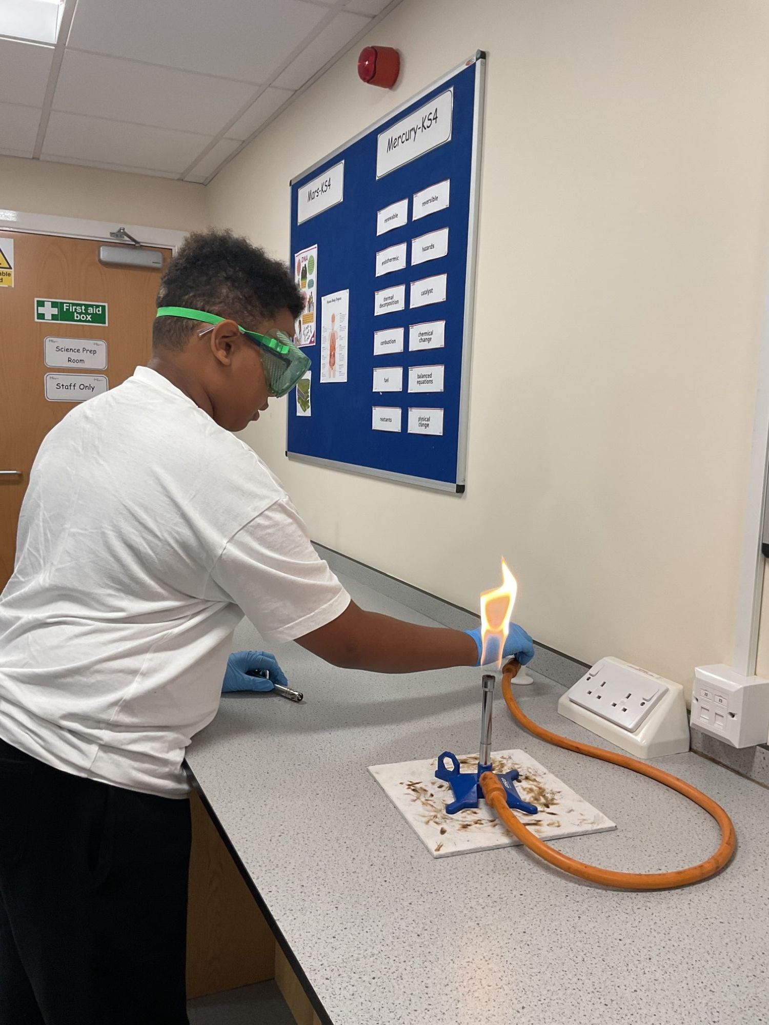 Student with a lit Bunsen burner