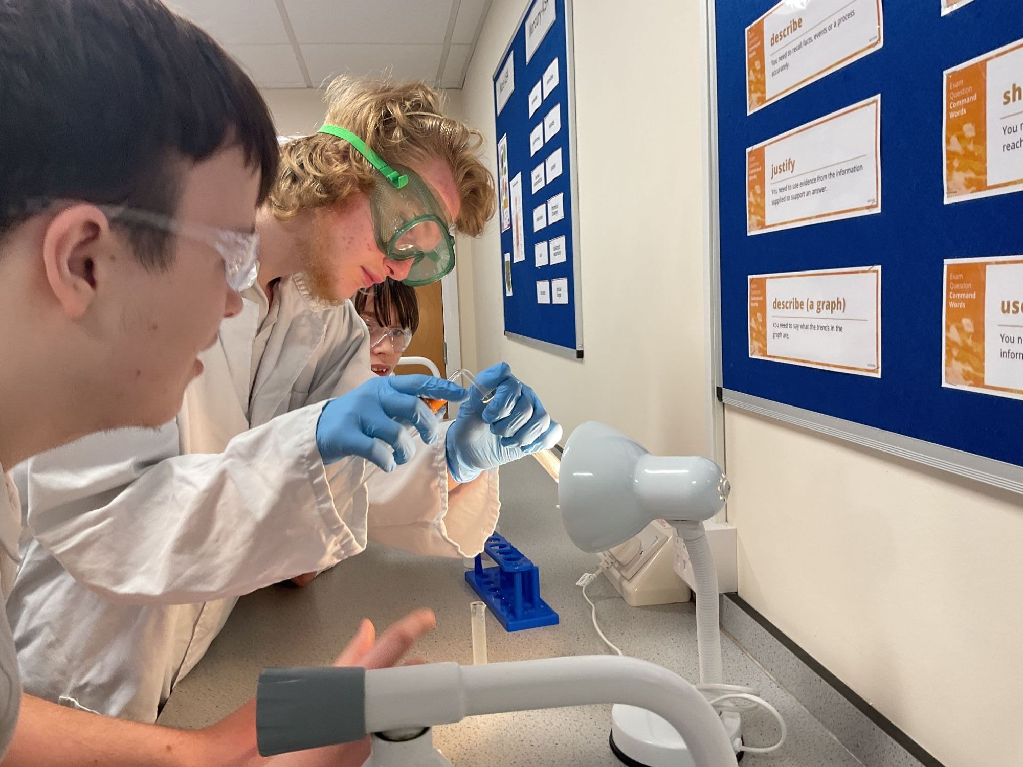 Two students working on their chemical reactions