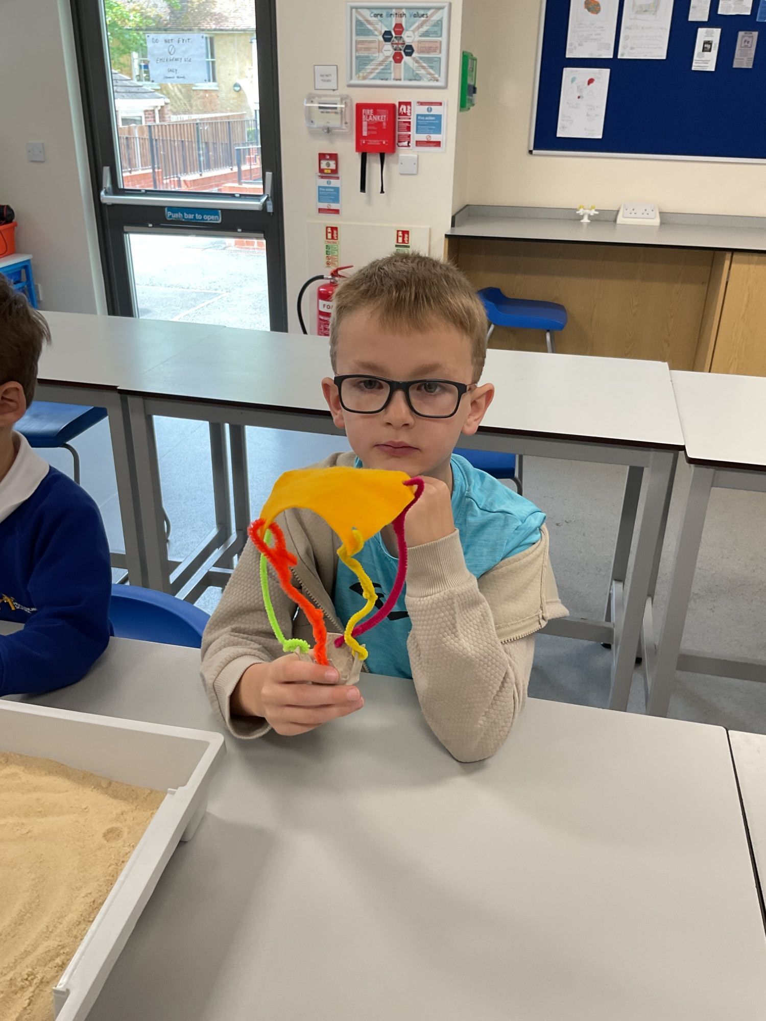 Foundation student looking at his model made with colourful pipe cleaners