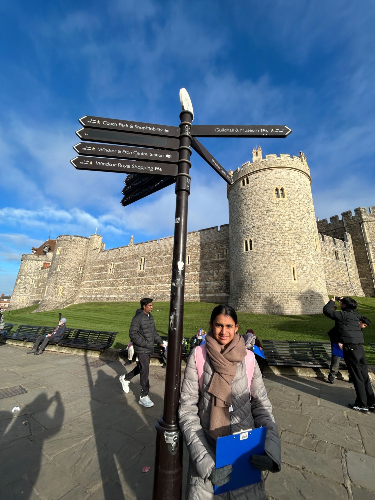 Student by a signpost outside the castle