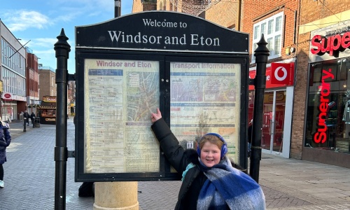 Student pointing at the Windsor & Eton information board