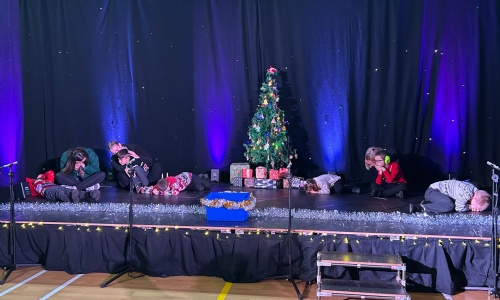 Children on stage pretending to be asleep