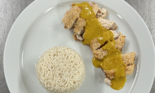 Finished chicken katsu curry (breaded chicked drizzled with sauce and a neat circle of rice)