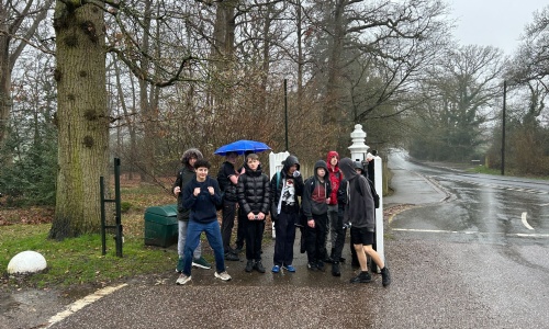 All the students standing  in a group in the rain near the end of the walk