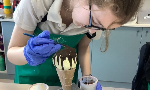 Student from Mercury Class painting her ice cream sculpture