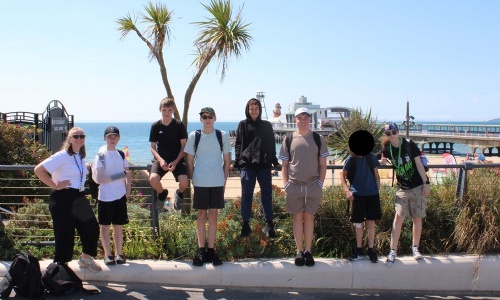 All the students on the trip lined up on the beach with their science teacher