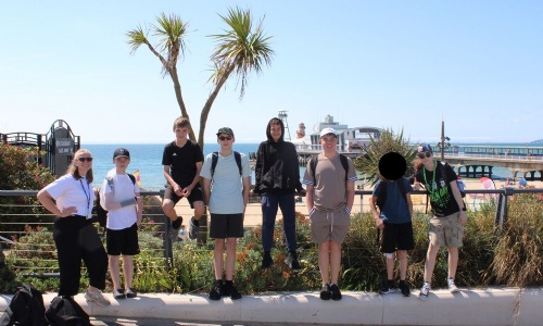 All the students on the trip lined up on the beach with their science teacher