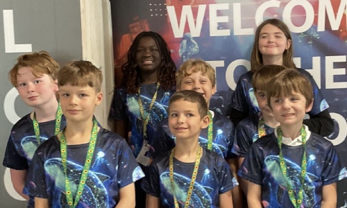 Close-up of the students who attended wearing their music festival tshirts by the welcome sign