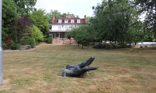 View of the main house with the crocodile statue at the bottom of the lawn