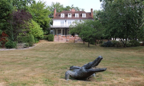 View of the main house with the crocodile statue at the bottom of the lawn