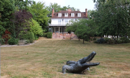 View of the main house and crocodile statue at the bottom of the lawn